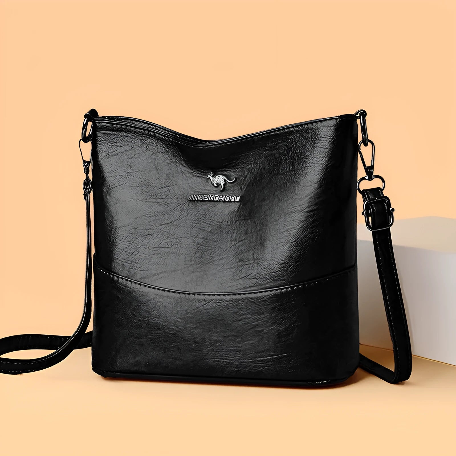 Women's soft leather shoulder bag in bucket design with minimalist luxury styling and mobile phone pocket