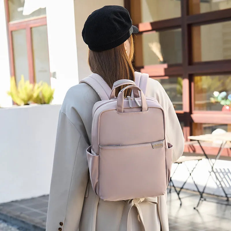 Simple large capacity women's canvas travel backpack in apricot colour, showing front view and organisational pockets.