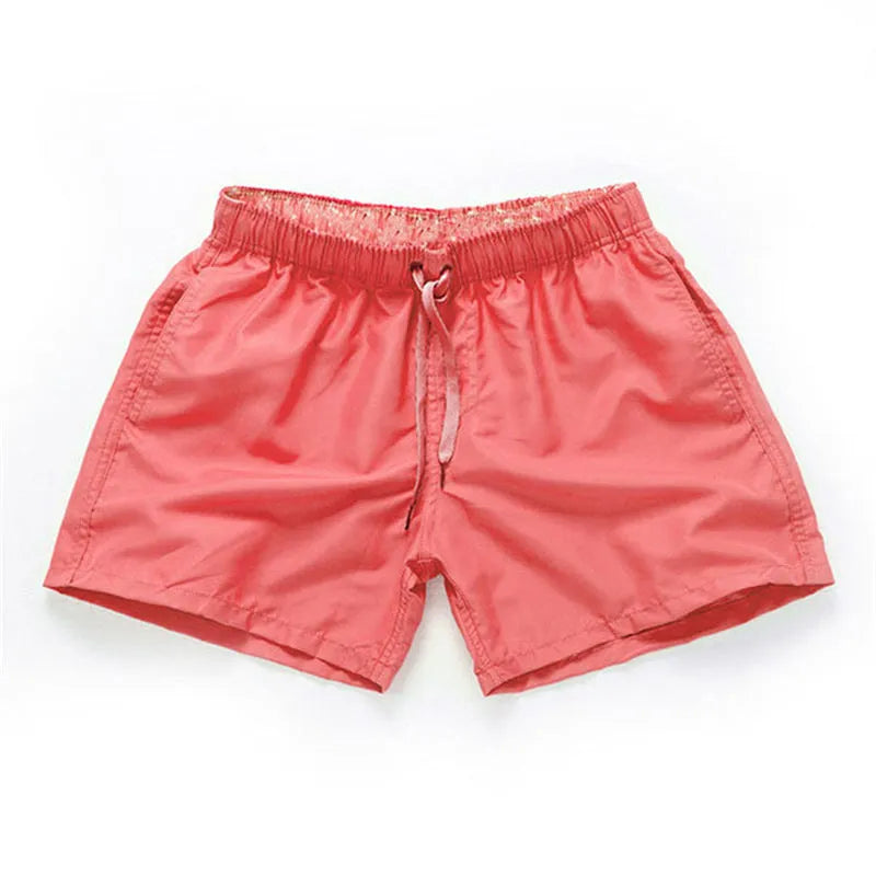 Men's straight leg beach shorts in polyester, shown in multiple colours including fluorescent yellow and navy blue.
