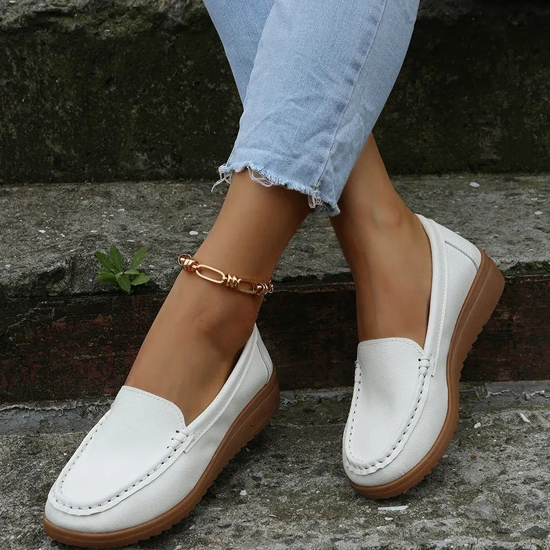 Women's flat loafers in PU leather with car-suture detail on a white background