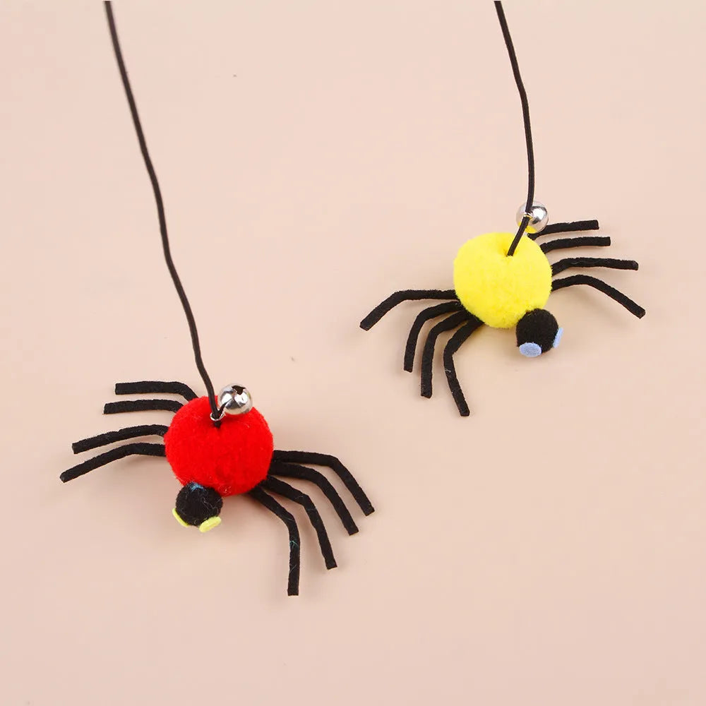 Cat hanging door toy with elastic rope, feather, bell and spider attachment on a white door.