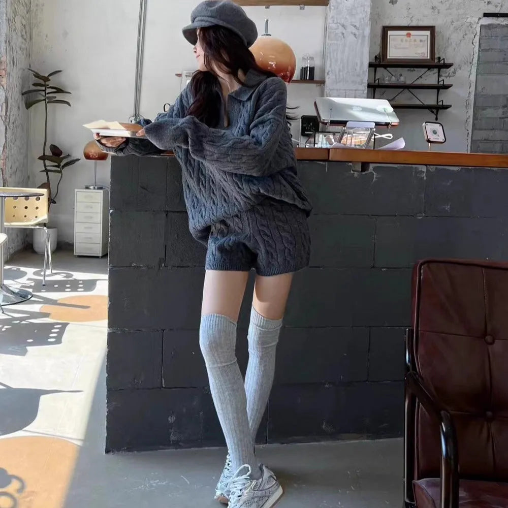 Creamy white geometric pattern cable knit sweater and elastic waist shorts set on a hanger.