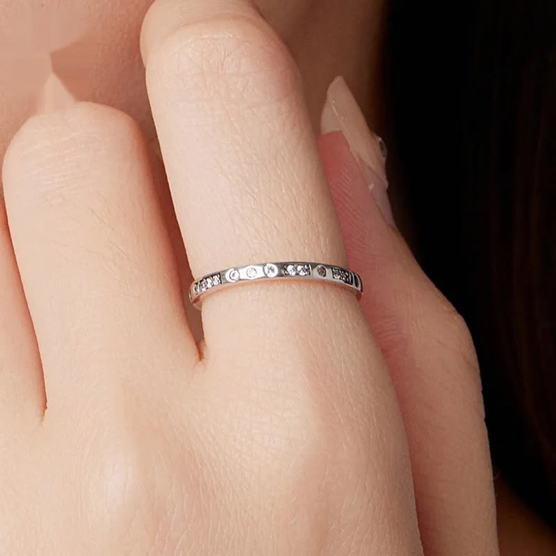 Simple silver Moss Password I Love You ring with oxidised black finish, shown on a model's finger.