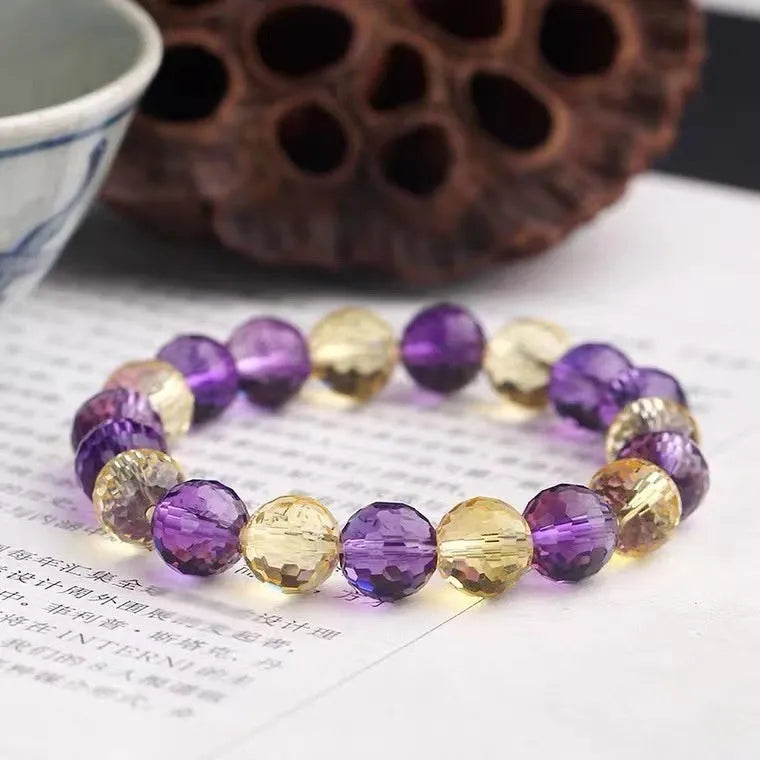 Handcrafted ametrine crystal bracelet with 128-faceted beads and a zodiac charm.