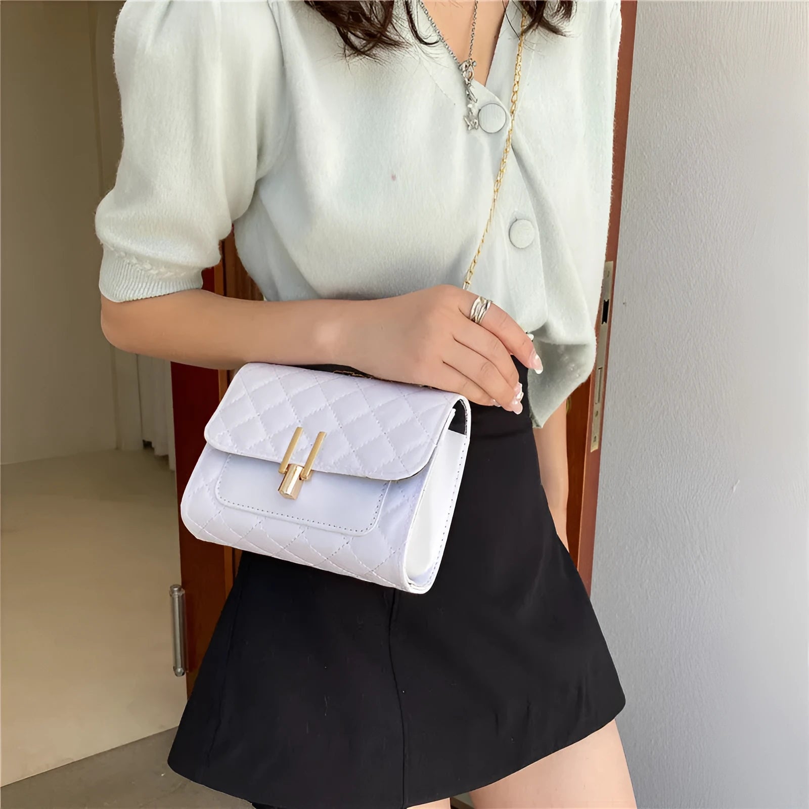 Women's minimalist crossbody bag with diamond lattice chain design in PU leather, showing adjustable strap and solid colour options