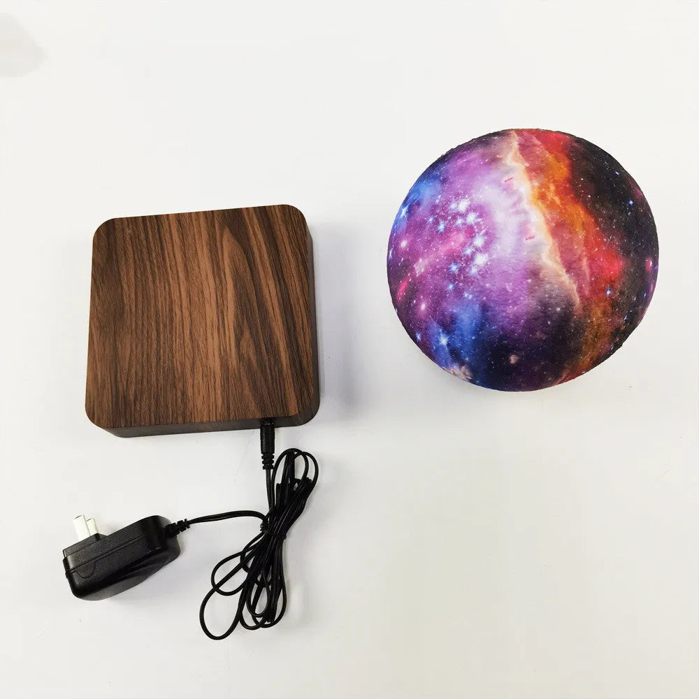 Levitating galaxy moon lamp floating above walnut colour base with starry light pattern