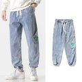 Men's loose-fit tapered cotton trousers in black, shown in a casual setting.