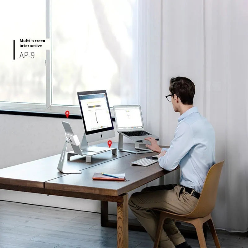 Black aluminium alloy laptop stand folded on desk next to silver version