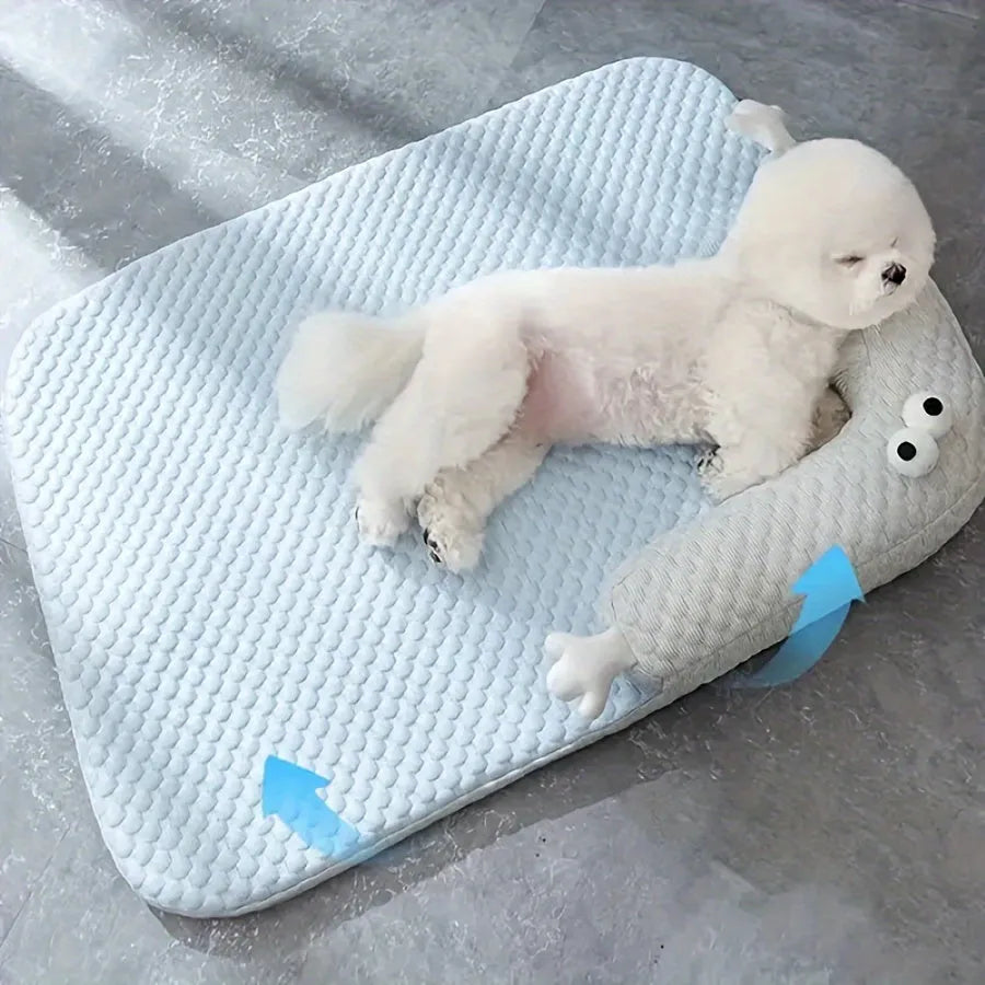 Blue pet cooling mat with big-eyed monster print on a wooden floor