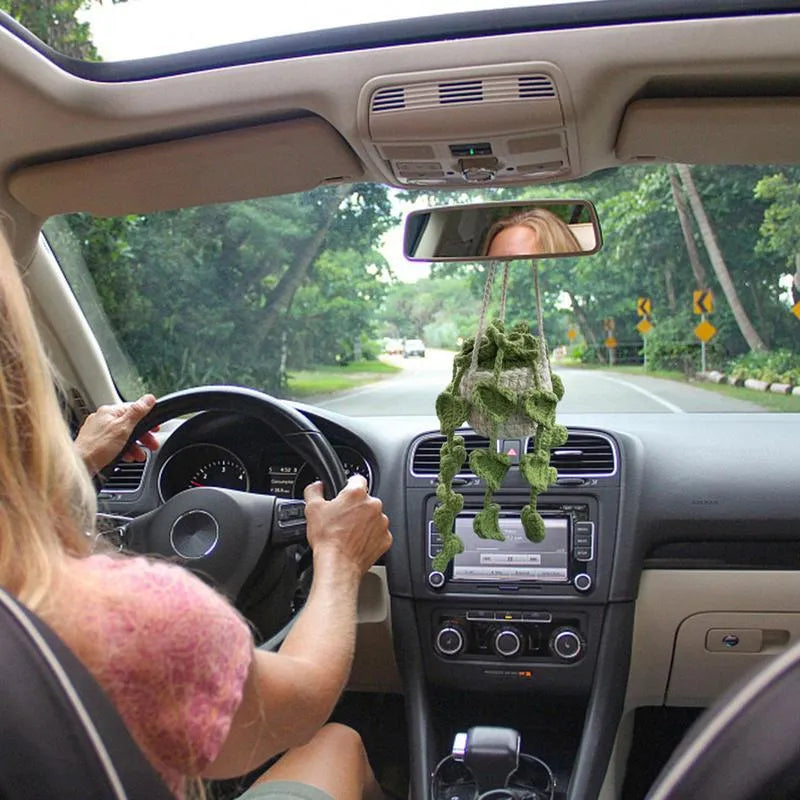 Green and white hand-knitted car plant ornament with a hanging cord on a basin-shaped base.