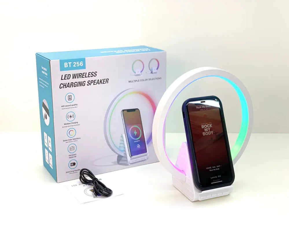 White rectangular smart device combining a wireless charging pad, Bluetooth speaker, and ambient light panel.