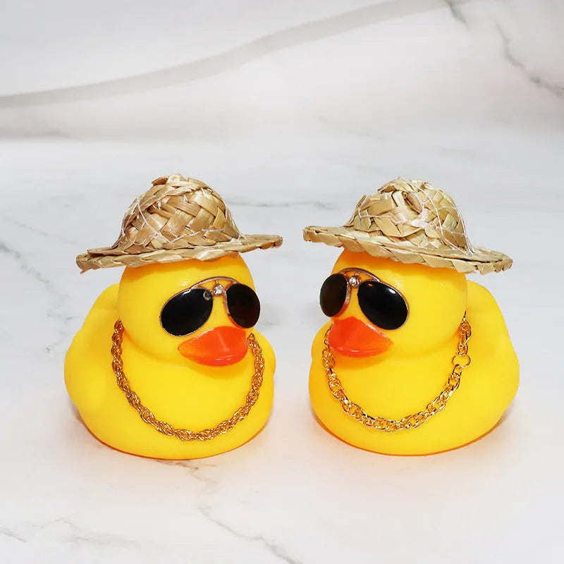 Cartoon yellow duck wearing a straw hat car dashboard ornament on a matte yellow base.