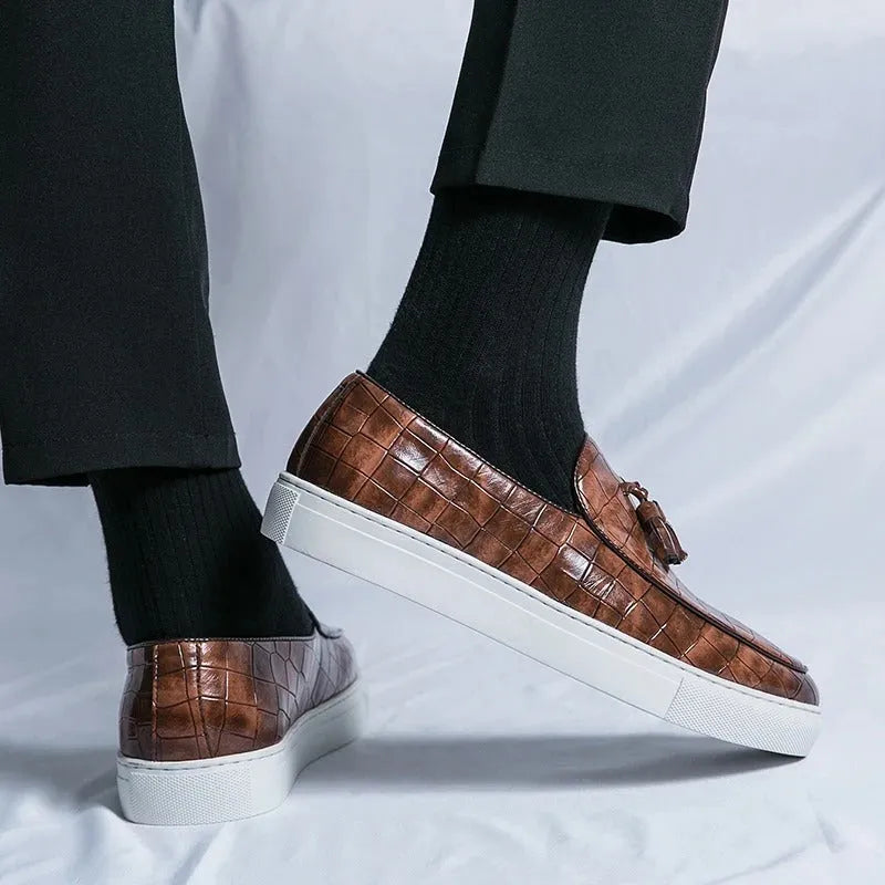 Men's black tassel detail slip-on sneakers with a round toe and rubber sole.