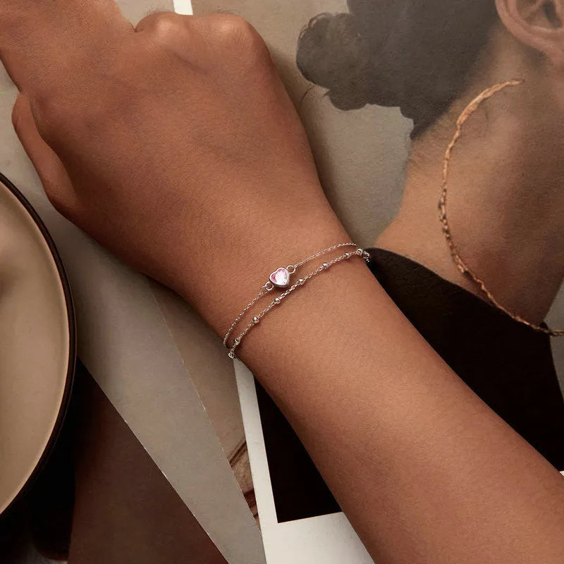 Sweet girlish style 925 sterling silver bracelet with a small heart-shaped charm on a chain.