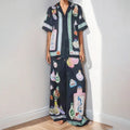 Black women's cardigan set with cartoon pattern, includes top with regular sleeves and matching trousers