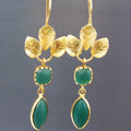 Gold drop shape retro earrings with French leaves tassel design and water drop zircon elements on copper background