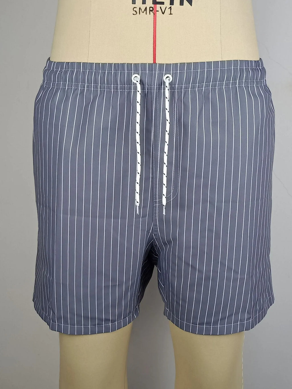 A pair of striped beach shorts in a polyester blend fabric, shown in a choice of colours with a straight leg cut.