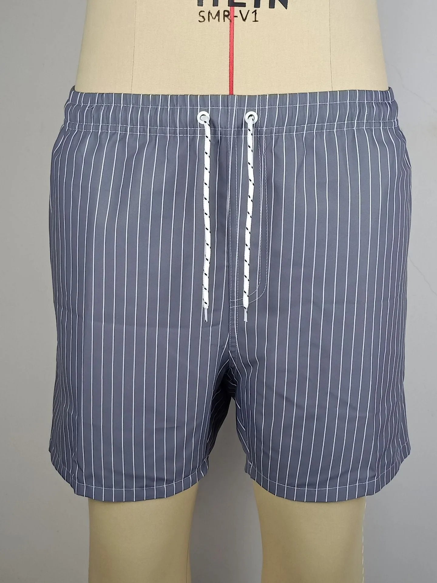 A pair of striped beach shorts in a polyester blend fabric, shown in a choice of colours with a straight leg cut.