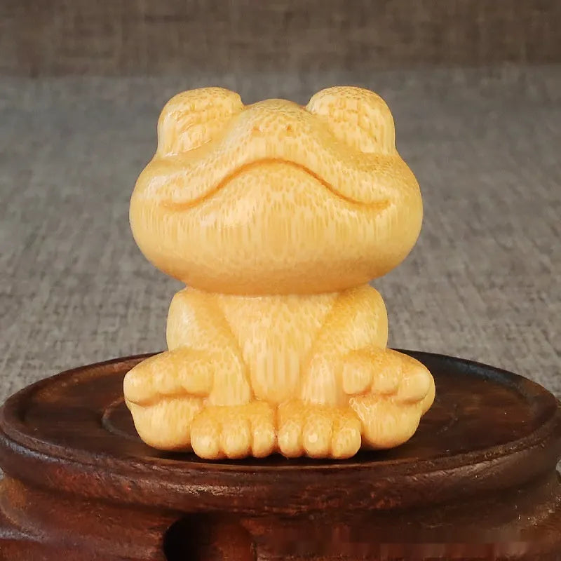 Solid bamboo carving ornament of a smiling cartoon frog, 5 cm tall.