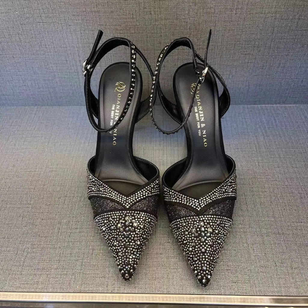 Black women's hollow high heels with pointed toe, stiletto heel, and red sole on a plain background.