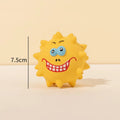 Set of four coloured latex squeaky dog balls with cute faces on a blue background