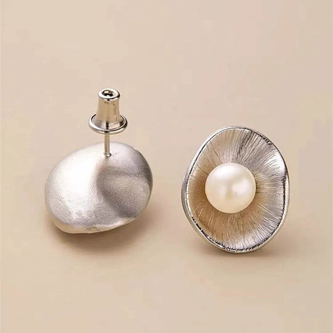 A pair of gold-coloured geometric sterling silver ear studs featuring pearl accents.