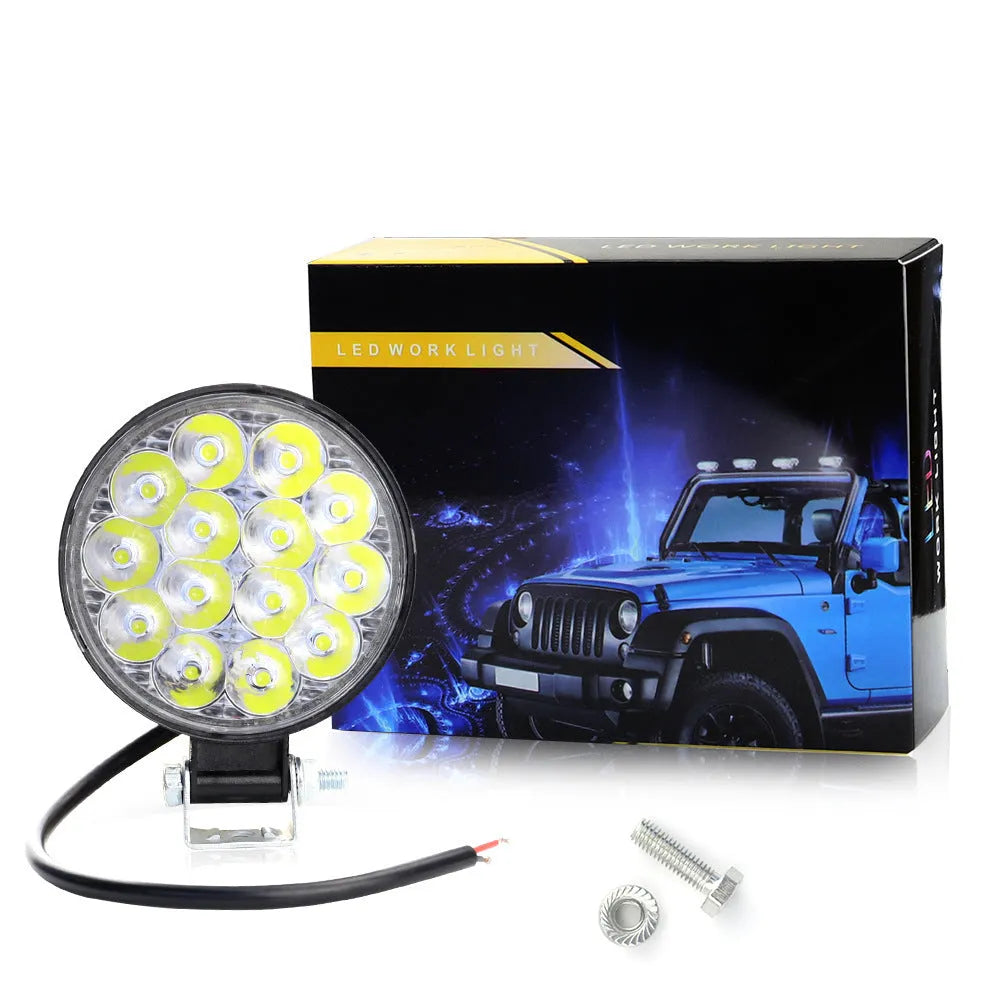 Compact round white LED work light with aluminium housing, suitable for mounting on a vehicle.