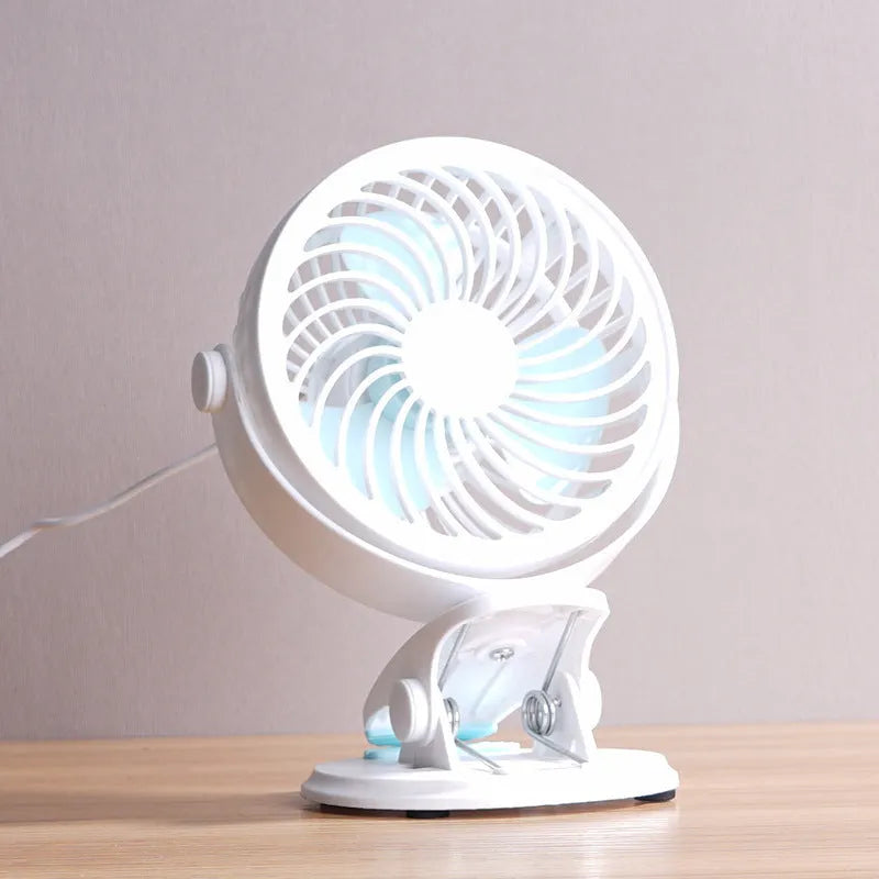 Small USB-powered desk fan shown in clip-on and floor-standing styles on a wooden desk.