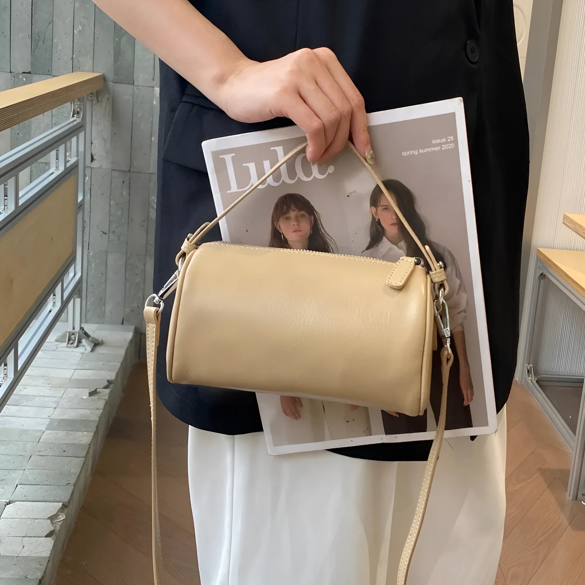 Vegetable tanned leather crossbody phone bag in cylindrical shape on a single adjustable strap.