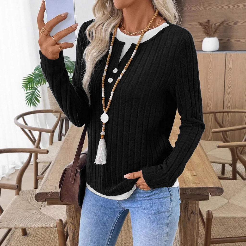 Women's black fake two-piece pullover sweater with button front and round neck on a model.