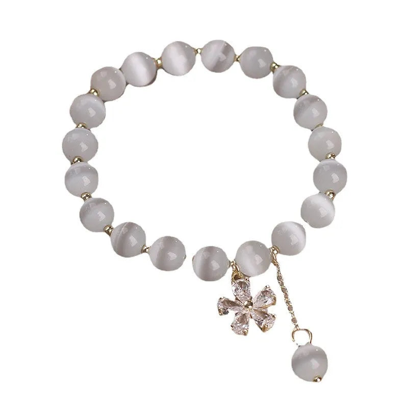 Women's white cat's eye stone bracelet with flower tassel detail and morganite safety buckle