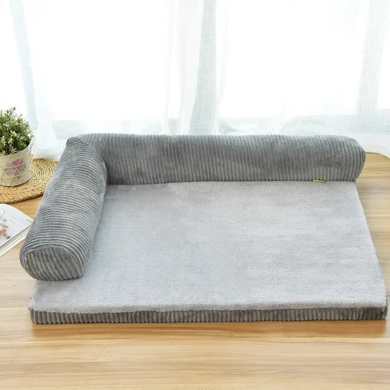 A corduroy dog sofa bed with raised sides, shown in a grey colour, placed on a wooden floor.