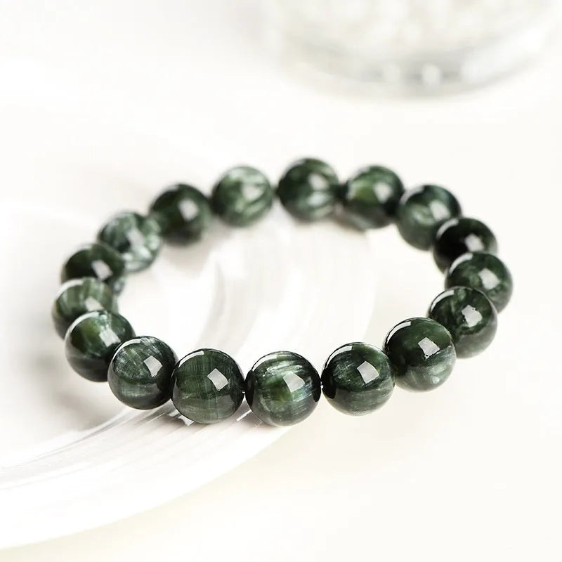 Natural green dragon crystal bracelet with 8-9mm round beads and Ruyi design on wrist.