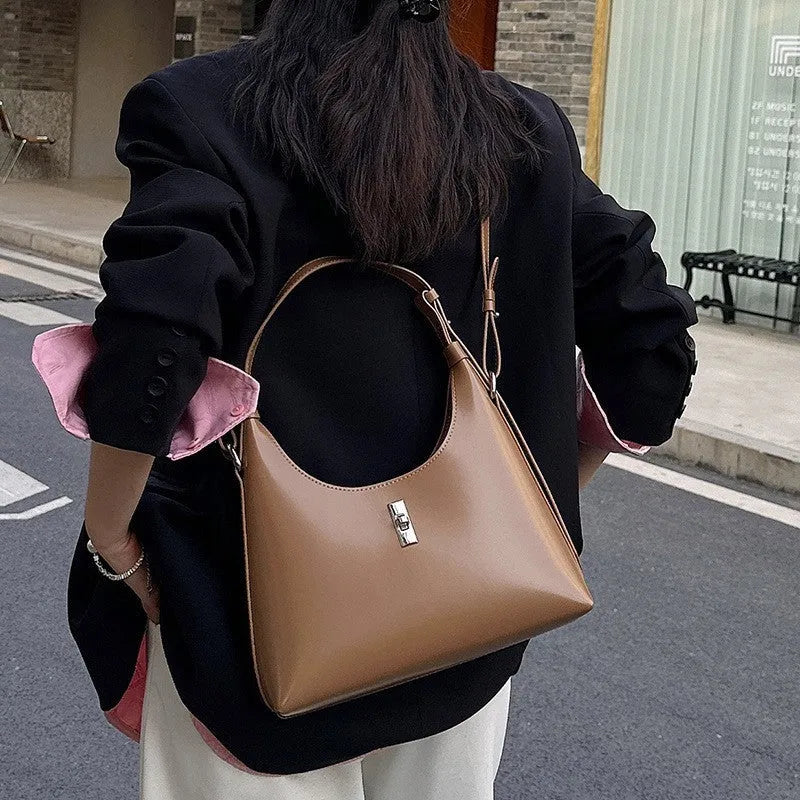 Women's soft genuine leather crossbody shoulder bag in a dumpling shape, shown in a light colour.