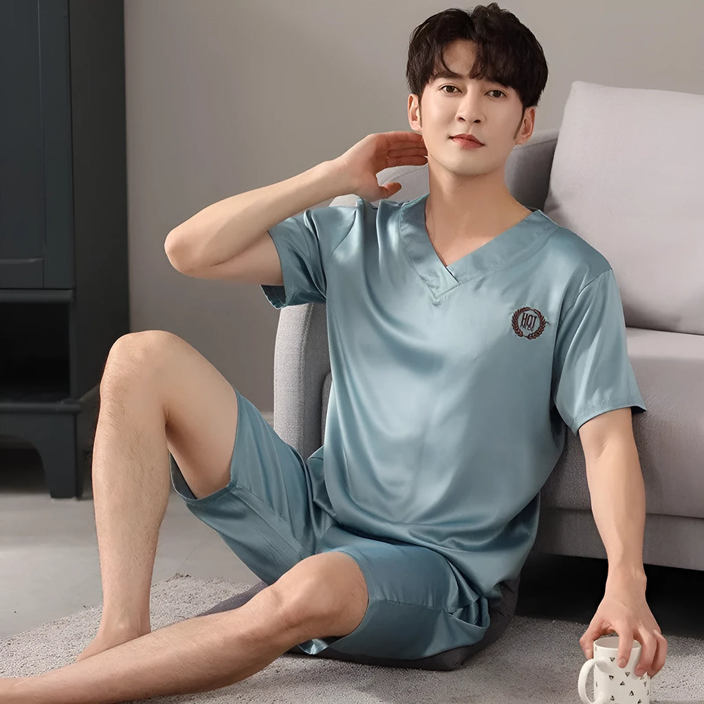 Man wearing a light blue loose-fit ice silk short sleeve pajama shirt and matching shorts.