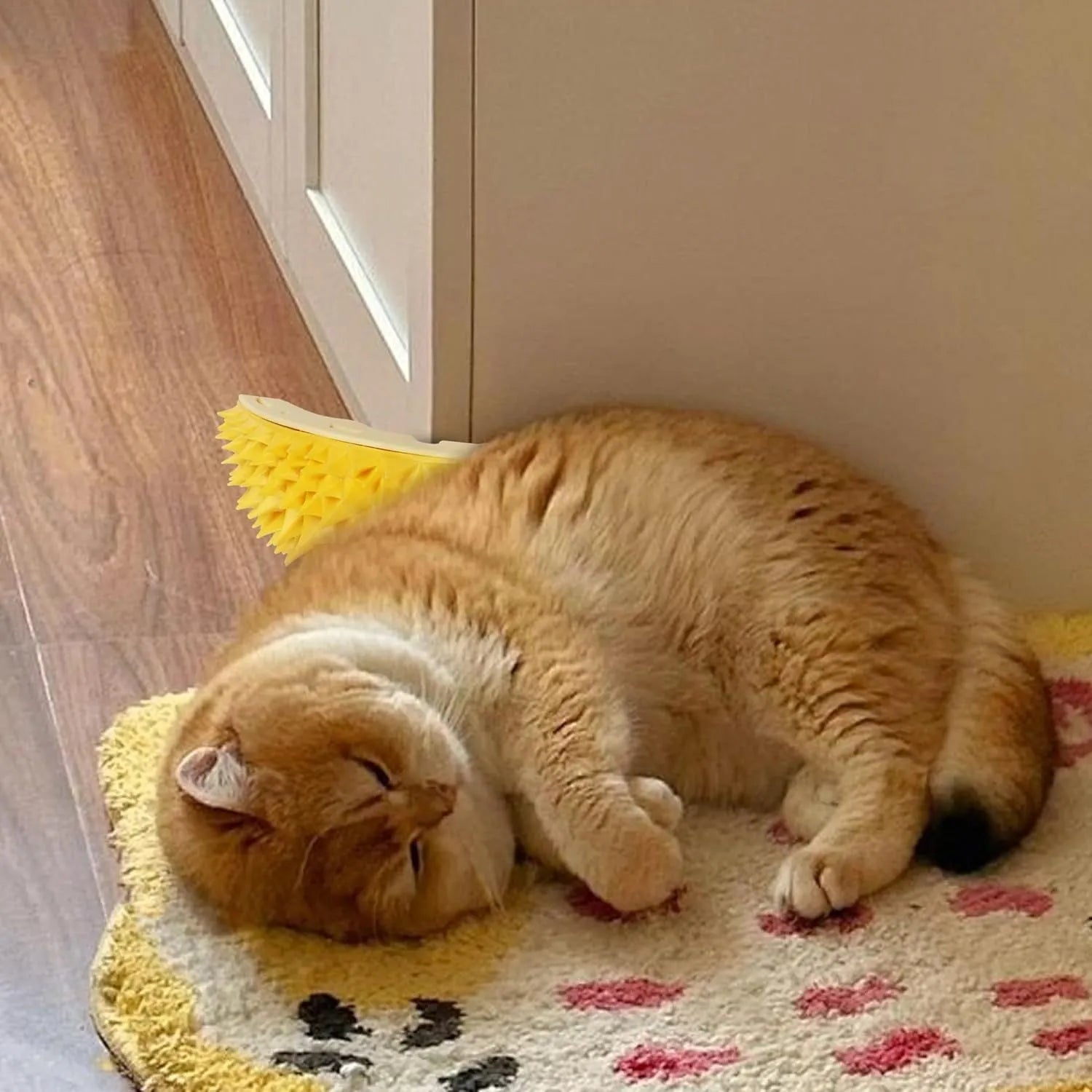 Yellow durian-shaped cat corner scratcher and grooming comb mounted on a wall.