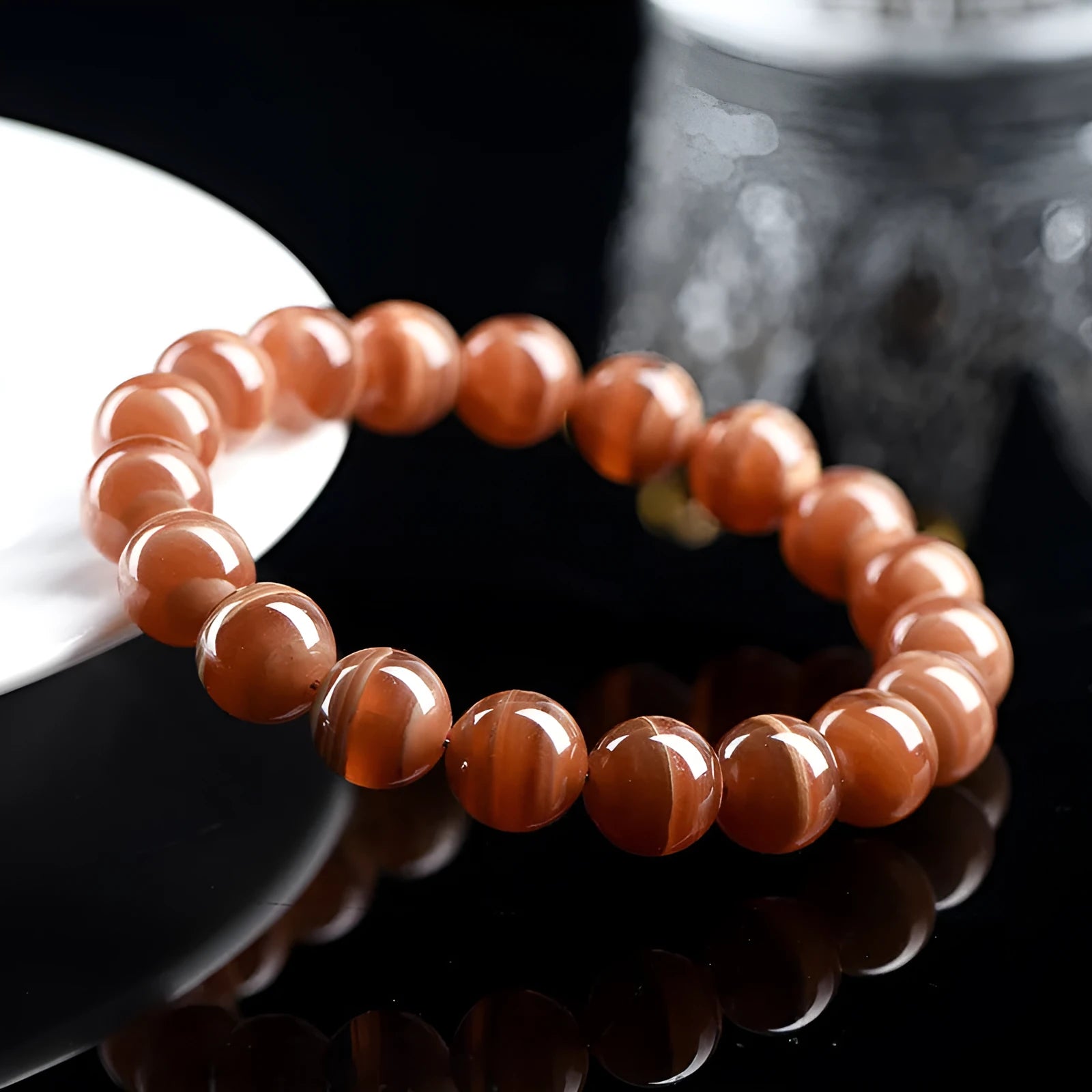 Natural old mine rhodochrosite round bead bracelet with Ruyi symbol on a wrist.