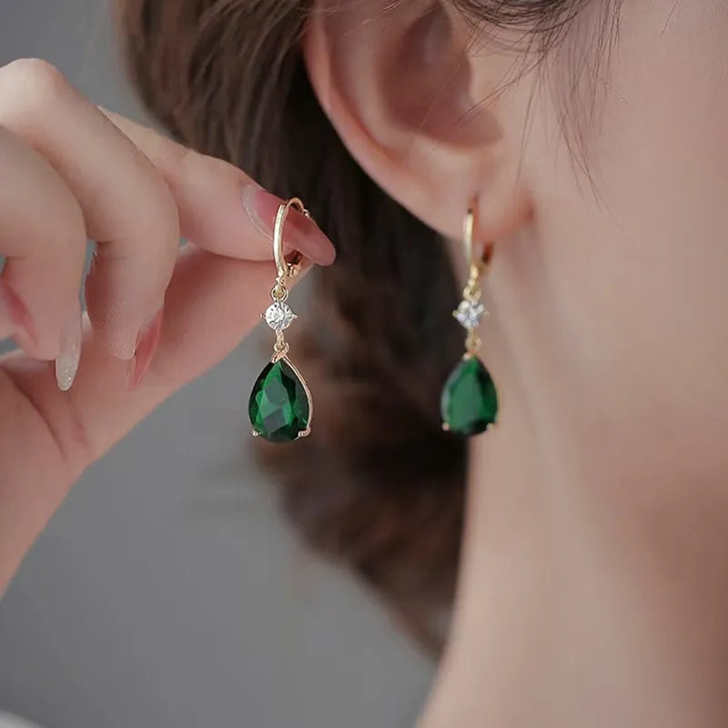 Emerald green geometric teardrop alloy earrings dangling from a model's ear.
