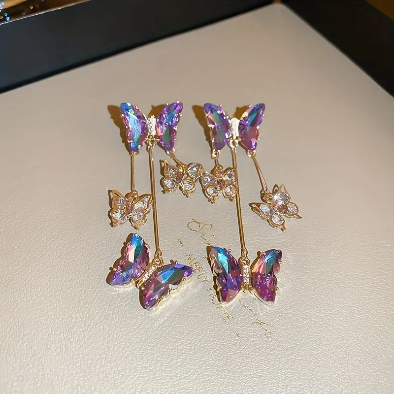 Blue purple butterfly earrings with crystal flowers and tassel details on silver needle posts
