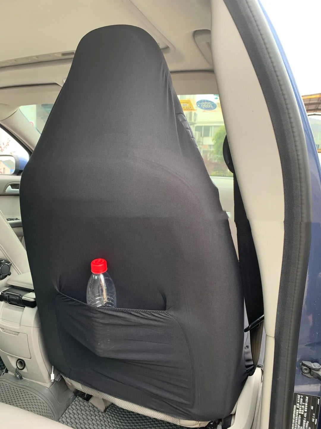 Black quilted automotive seat cover made from PU and polyester fabric on a car seat.
