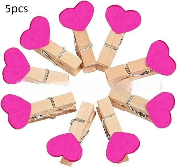 Five solid wood heart-shaped clips in red, rose red, and white colours on a natural background.