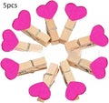 Five solid wood heart-shaped clips in red, rose red, and white colours on a natural background.