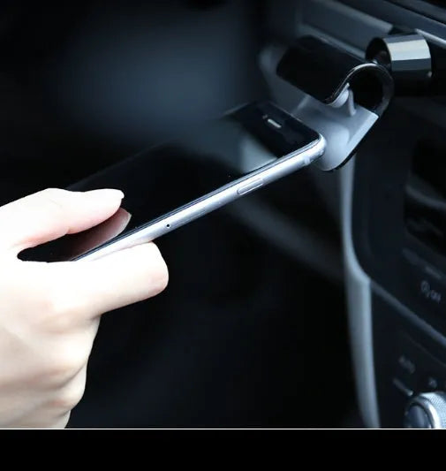 Black universal car phone holder with 360-degree rotating ball joint on a car dashboard.