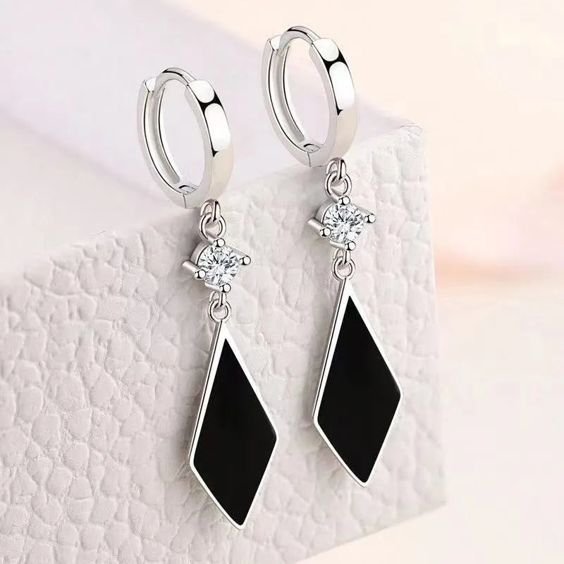 Silver vintage geometric diamond-shaped clip-on earrings on a plain background.