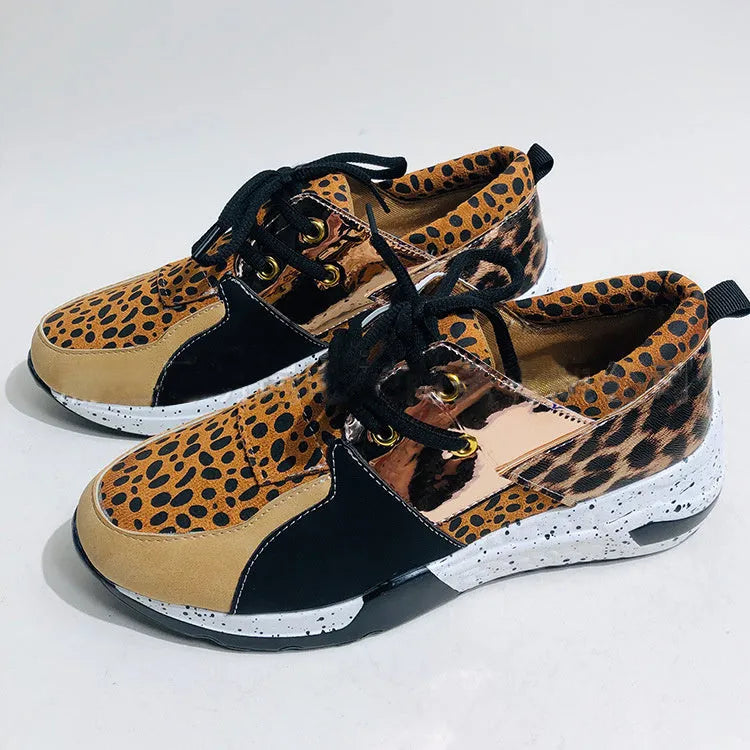 Women's casual flat sneakers in leopard print with suede upper and a low wedge heel.