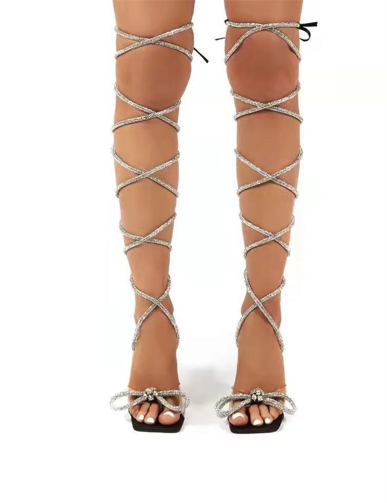Plus size women's black strappy sandals with decorative Roman rhinestone straps and a square toe.