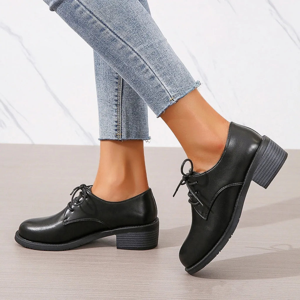 Black women's low-top work shoes with a thick chunky rubber heel and a PU leather upper