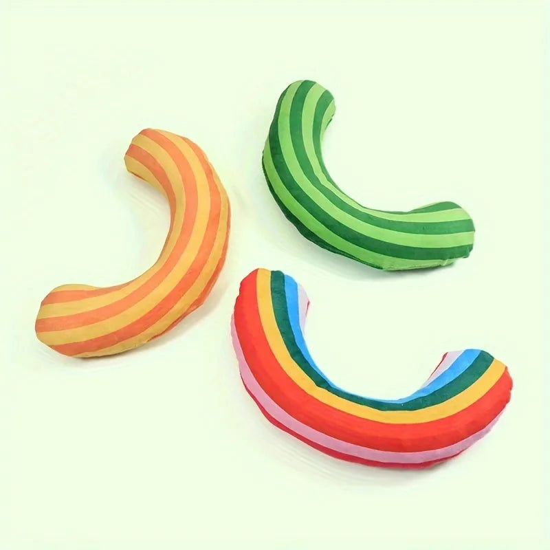 Green, rainbow, and yellow cat toy set with noise maker, catnip strip, and striped plush pillow.