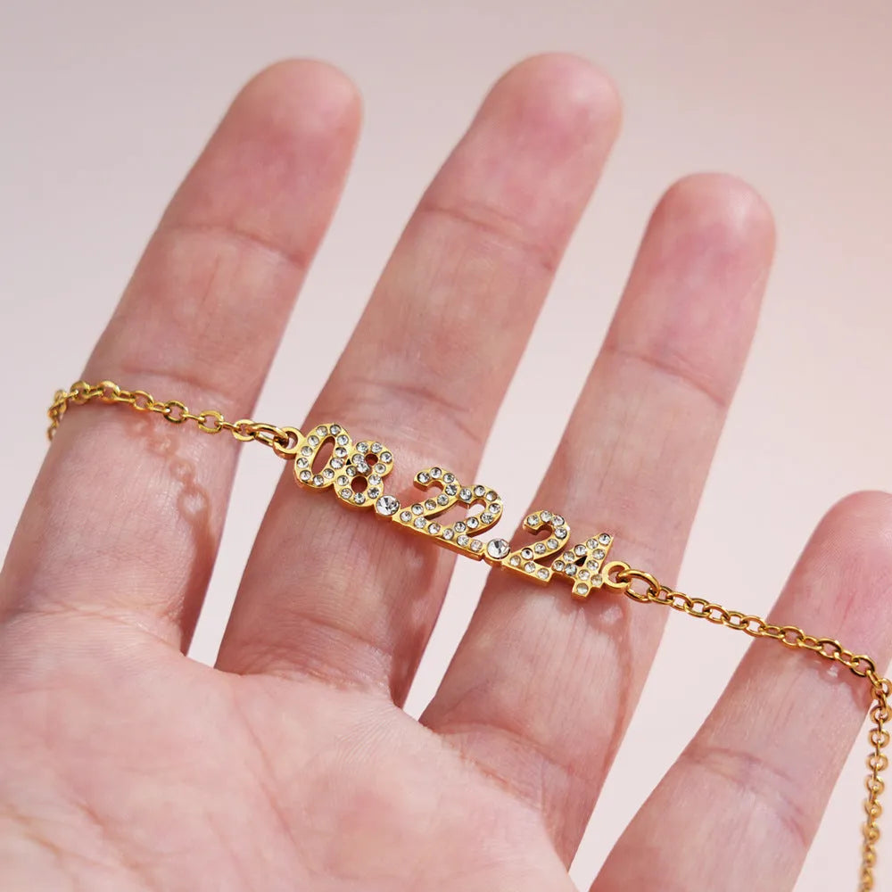 Stainless steel digital bracelet with diamond-set numbers on display, shown in gold colour.