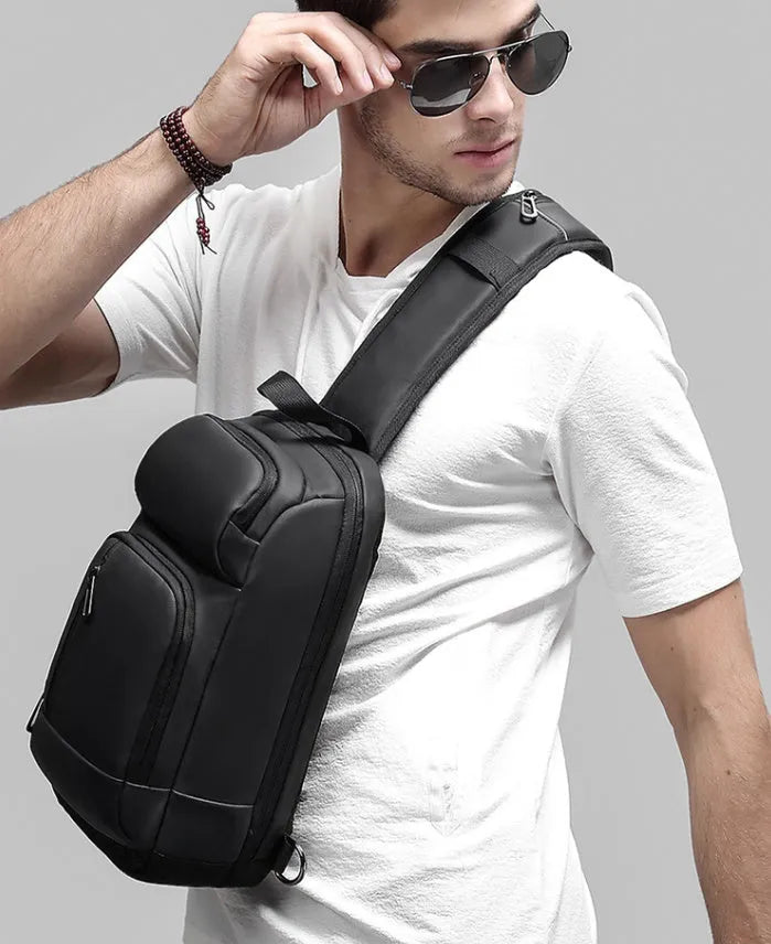 Black medium PVC outdoor shoulder bag showing air cushion strap, soft handle, and internal organiser pockets.